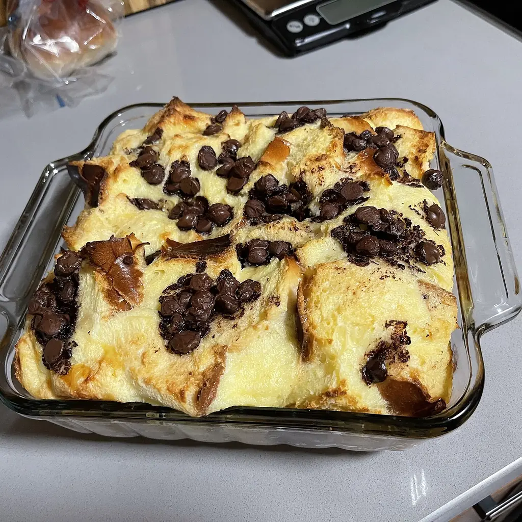 Bread pudding with raisins baked in a glass dish.