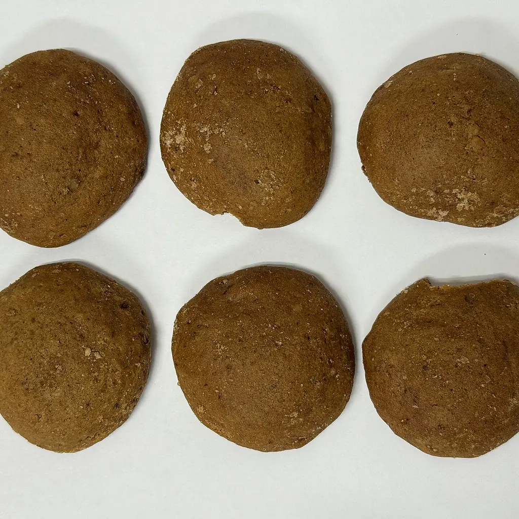 Round molasses cookies arranged on a white plate.
