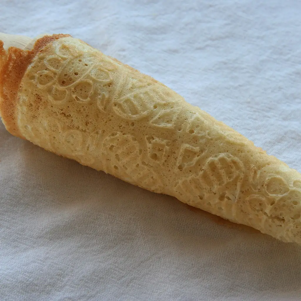 A patterned krumkake wafer rolled into a cone.