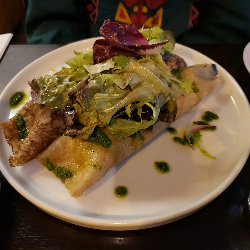 Savory mushroom-filled crepes served with salad leaves.
