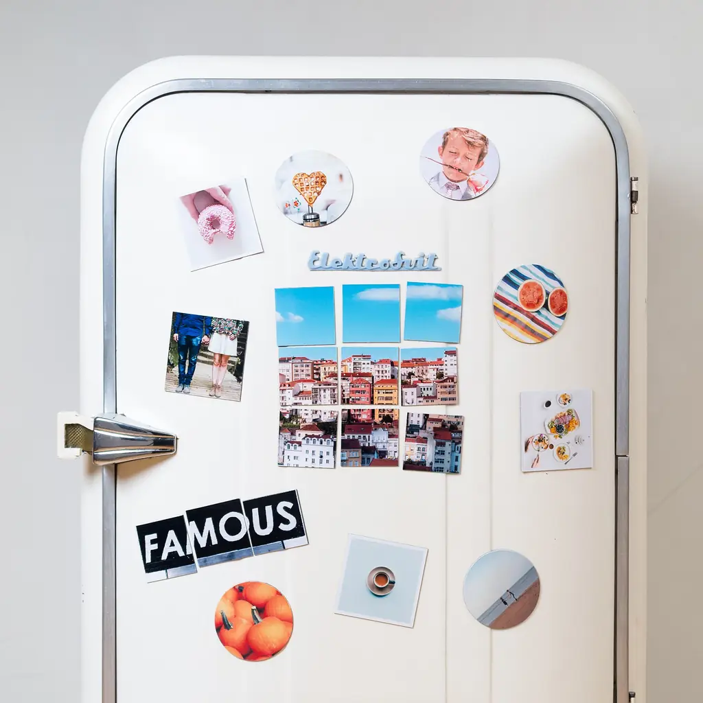 The door of a vintage refrigerator decorated with magnets.