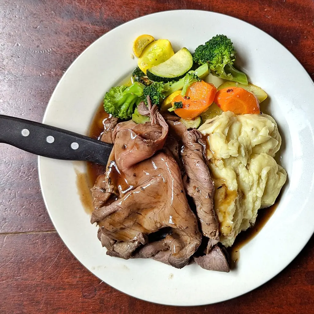 A roast with a bowl of gravy