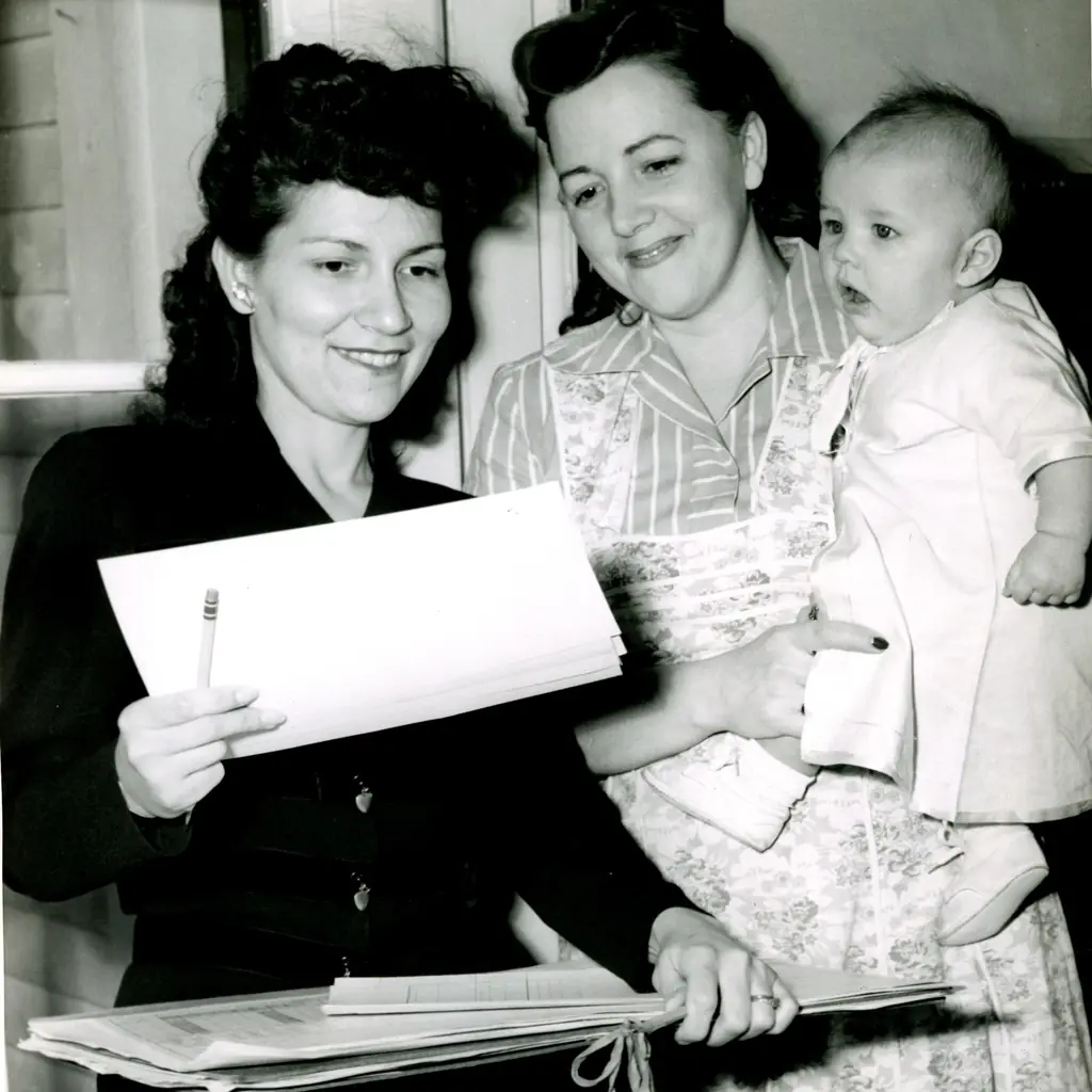 A census enumerator's visit in 1950, with a mother holding a baby.